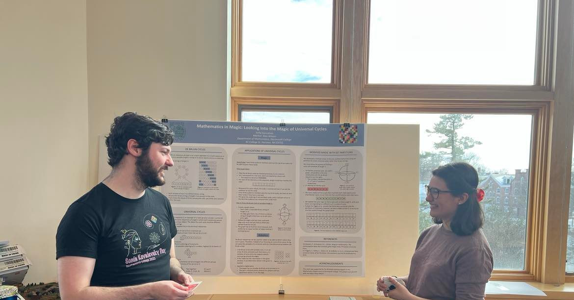 A mentor and student standing in front of the student's poster